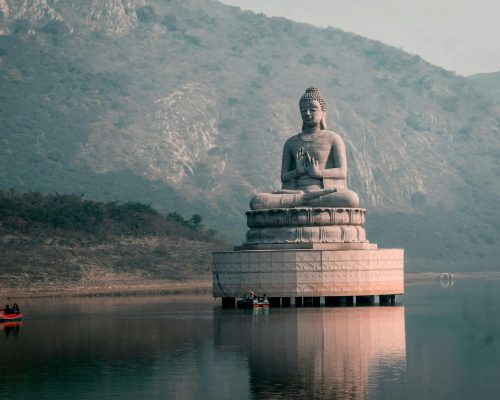 Majestic Buddha statue on Ghora Katora Lake surrounded by hills in Bihar, India.